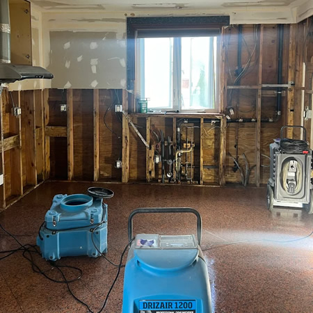 Technician setting up negative air containment for mold remediation